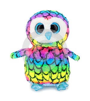 Cute rainbow colored owl plushie doll isolated on white background with shadow reflection. Plush stuffed puppet bird toy.
