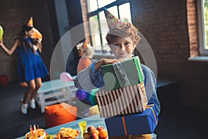 Cute red-haired boy holding presents and smiling