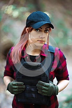 Cute red-haired girl in a cap and body armor