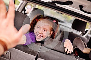 Cute red-haired girl smiling in car salon