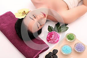 Cute relaxed young woman laying in spa salon with closed eyes