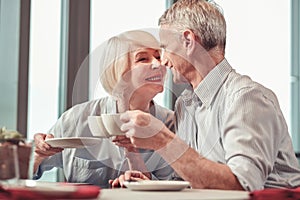 Cute retired man and woman drinking coffee