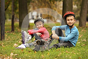 Cute roller skaters sitting on grass