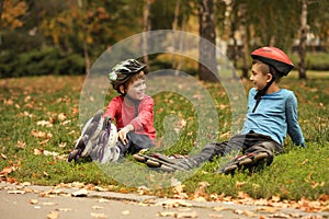 Cute roller skaters sitting on grass