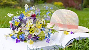 A cute romantic bouquet of wildflowers and meadow flowers of daisy, forget-me-nots, pansies as an art of floristry design.