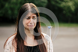 cute sad woman looking at banged blue balloon with crying emotion photo