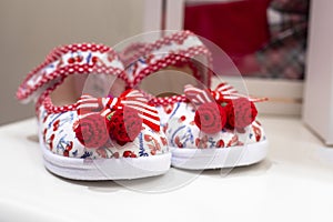 cute sandals for a child with red knitted buboes. Summer photo