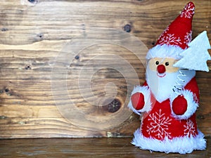 Cute Santa Claus standing on wooden table and wooden background , Merry Christmas and happy new year.