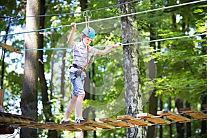 Cute school boy in a climbing activity park