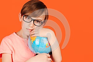 Cute school boy hugging the earth globe. Save the earth. Happy kid in glasses holding Earth world globe