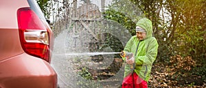 Cute school little girl washing car near house. Kids home errands duty chores responsibility concept. Child playing with