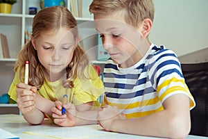 Cute schoolchildren are came back to school and learning at the table in classroom