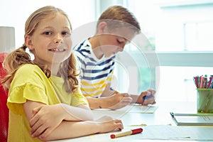 Cute schoolchildren are came back to school and learning at the table in classroom