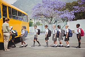 Cute schoolchildren waiting to get on school bus