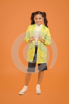 Cute schoolgirl feel protected. Happy schoolgirl wear raincoat. Invest in durable kids rainwear to keep children out in