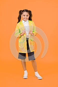 Cute schoolgirl feel protected. Happy schoolgirl wear raincoat. Invest in durable kids rainwear to keep children out in