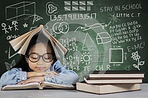 Cute schoolgirl reading textbook with doodle