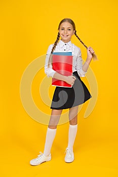 Cute schoolgirl. School education. Courses for gifted children. Basic level. Happy schoolgirl hold textbooks yellow photo