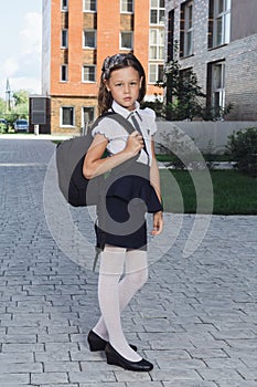 Cute schoolgirl in uniform standing in campus