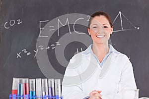 Cute scientist standing in front of a blackboard photo