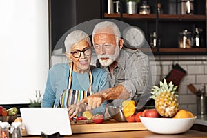 Cute senior couple preparing some healthy meal in the kitchen