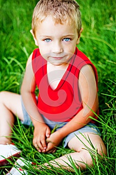 Cute serene kid on fresh green grass