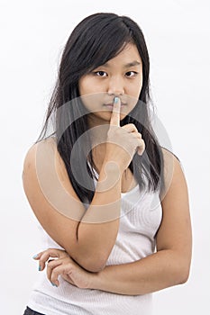 Cute serious asian girl on isolated background thinking making silence sign