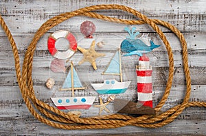 set of kids handcrafted boats, fish, nautical attributes and more on rough vintage wooden background top view