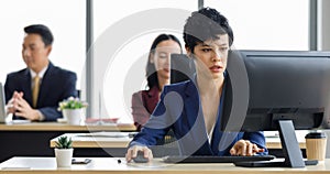 Cute short hair businesswoman working in offce with her colleagues sitting blur in background