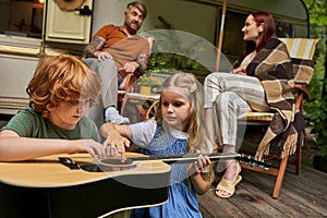 cute siblings learning to play guitar