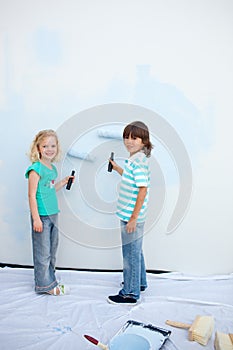 Cute siblings painting a wall