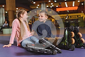 cute siblings in roller skates resting after skating