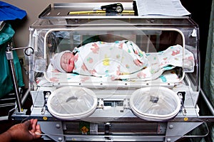 Cute sick baby in incubator