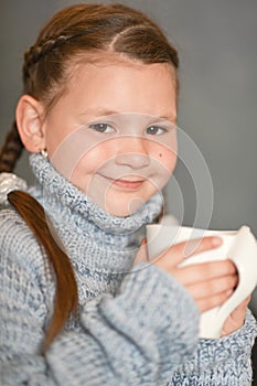 Cute sick girl with cup of rea