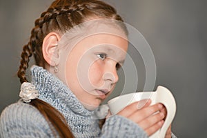 Cute sick girl with cup of rea