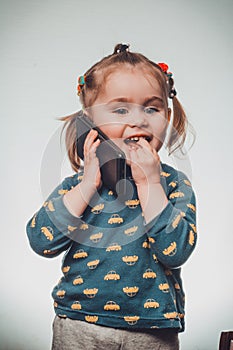 Cute and sincere beautiful girl talking on the phone, portrait of girl 3-4 years