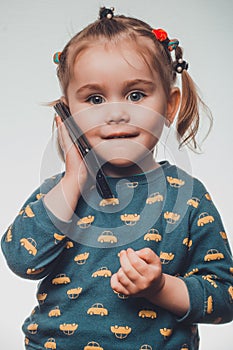 Cute and sincere beautiful girl talking on the phone, portrait of girl 3-4 years