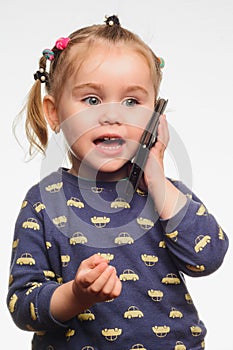 Cute and sincere beautiful girl talking on the phone, portrait of girl 3-4 years