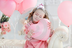 Cute six year old girl in pink dress with pink balloons in the shape of heart