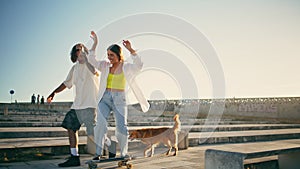 Cute skaters learning skateboard tricks street. Couple having fun riding skate