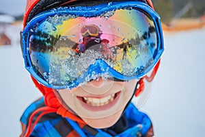 Cute skier boy in a winter ski resort.