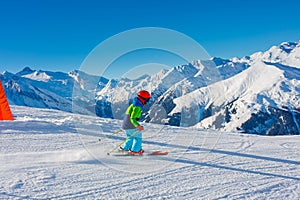 Cute skier boy in a winter ski resort.