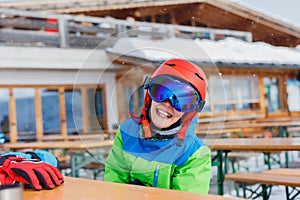 Cute skier boy in a winter ski resort.