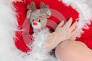 Cute sleeping baby in red hat on little bed
