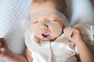 Cute sleeping baby wear white pajamas lying in crib close up. Healthy sleep. Childhood