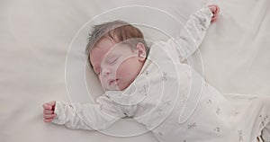 Cute, sleeping and newborn baby on a bed at a home in the bedroom for resting and dreaming. Tired, sweet and top view of