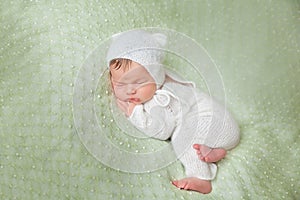 Cute sleeping newborn baby in white knitted fluffy kitten costume
