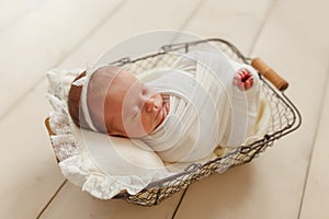 Cute sleeping newborn girl with a bandage on her head on a small