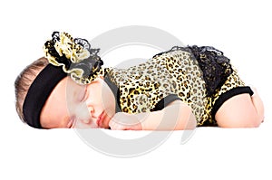 Cute sleeping newborn girl in a leopard clothes