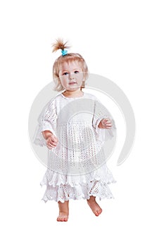 Cute small baby girl in hand made lace dress walking towards camera